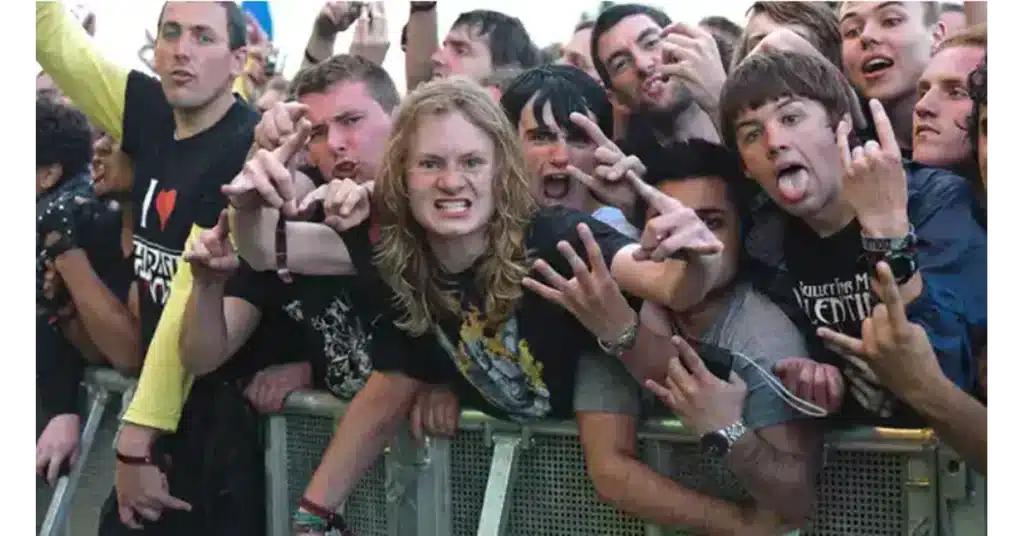crowd enjoying rock concert with a blonde guy with long hair in the middle